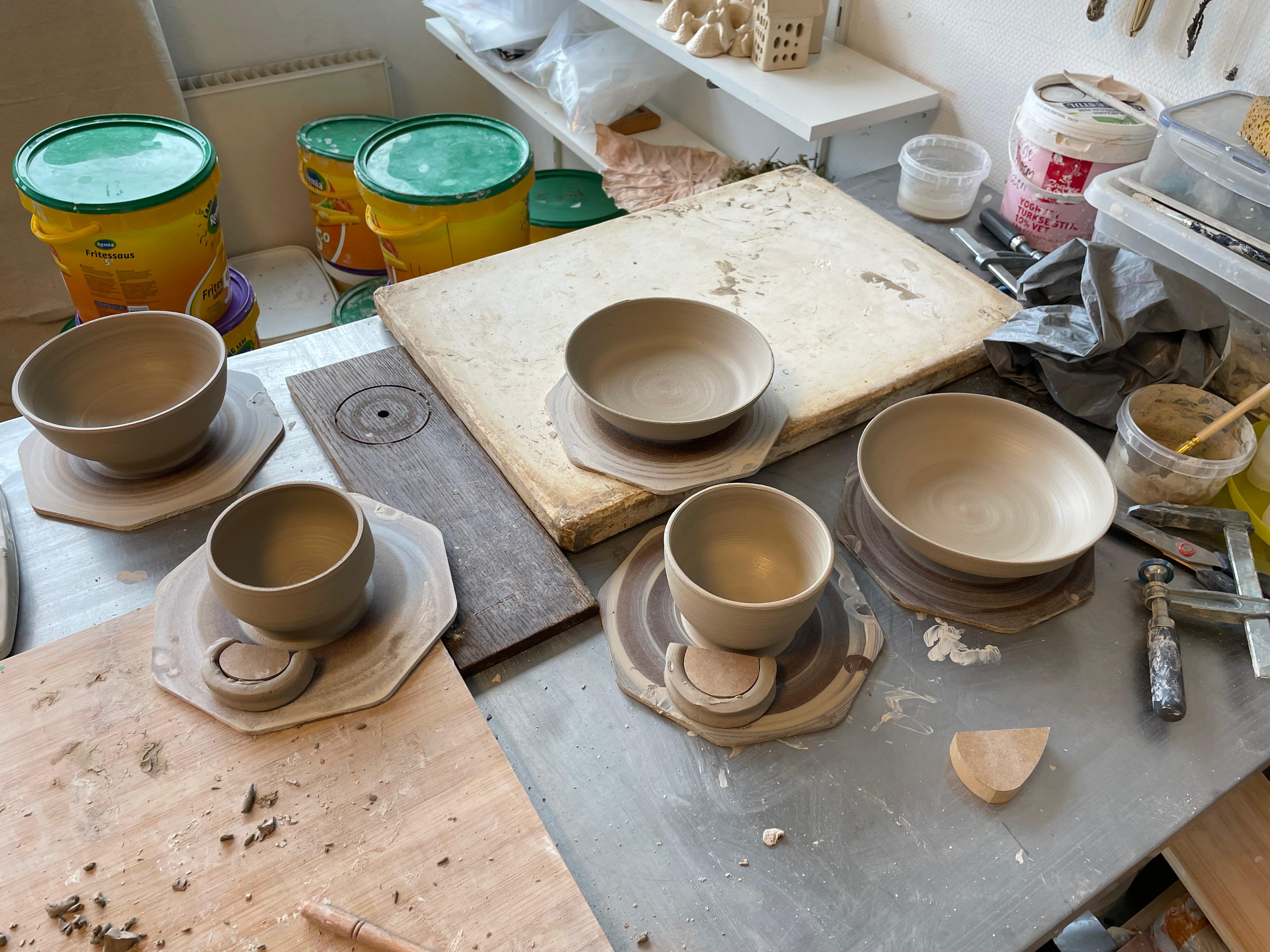 Fresh wheel-thrown pottery bowls and cups in the studio
