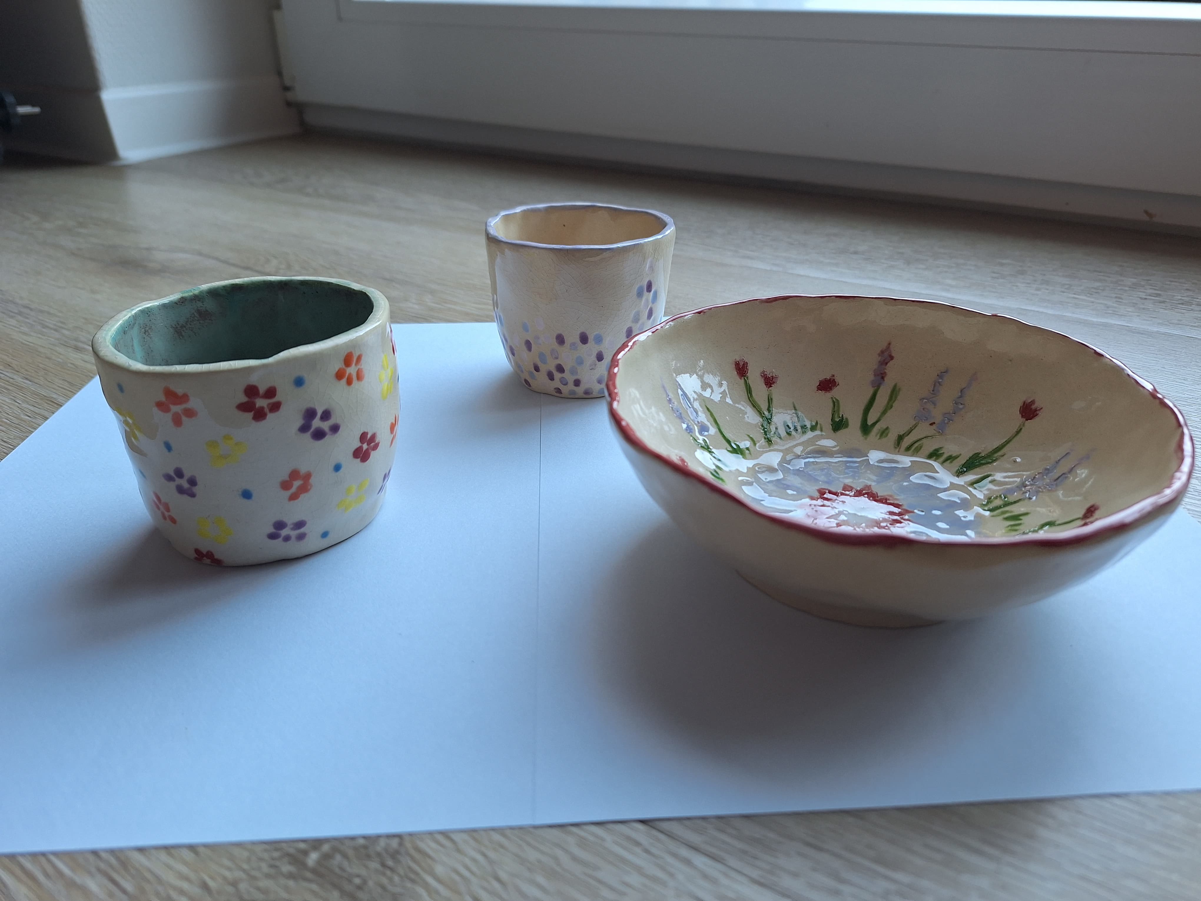 Flower-decorated ceramic bowl and cups set with colorful glazes
